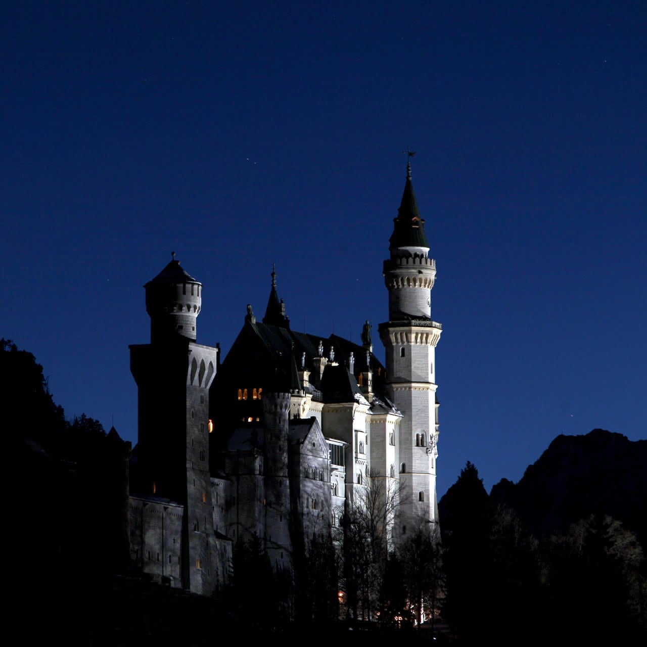 Neuschwanstein zur blauen Stunde. Schloss Neuschwanstein bei Füssen in Bayern erleuchtet während der blauen Stunde.