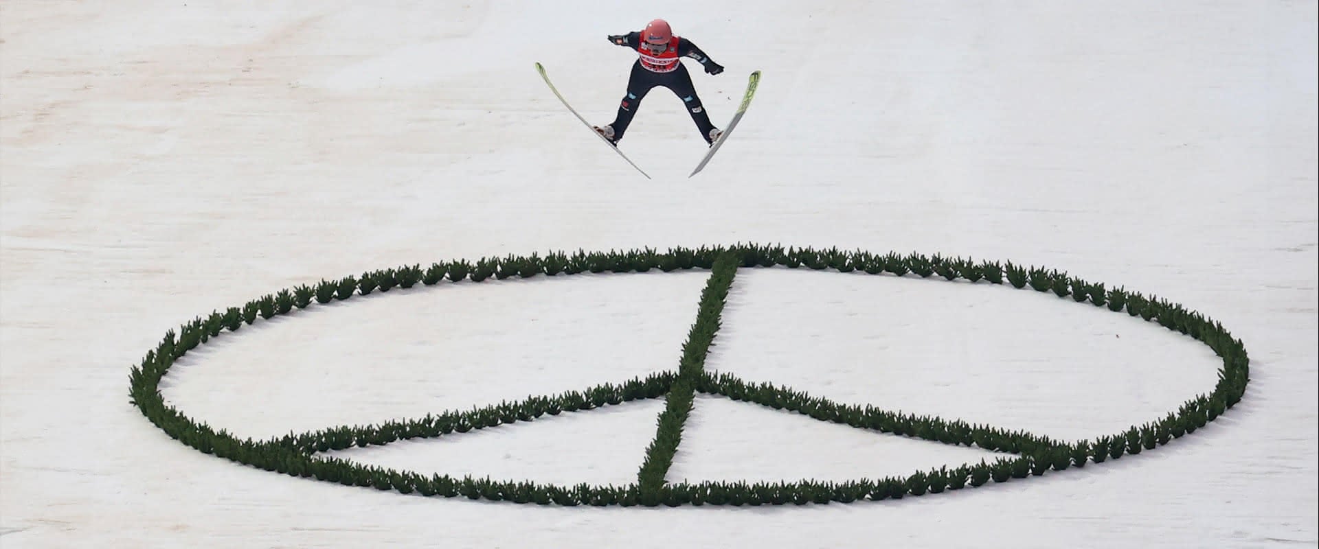 Karl Geiger beim Weltcup-Skifliegen über einem Peace-Zeichen auf der Heini-Klopfer-Schanze als Solidaritätsbekundung für die Ukraine.