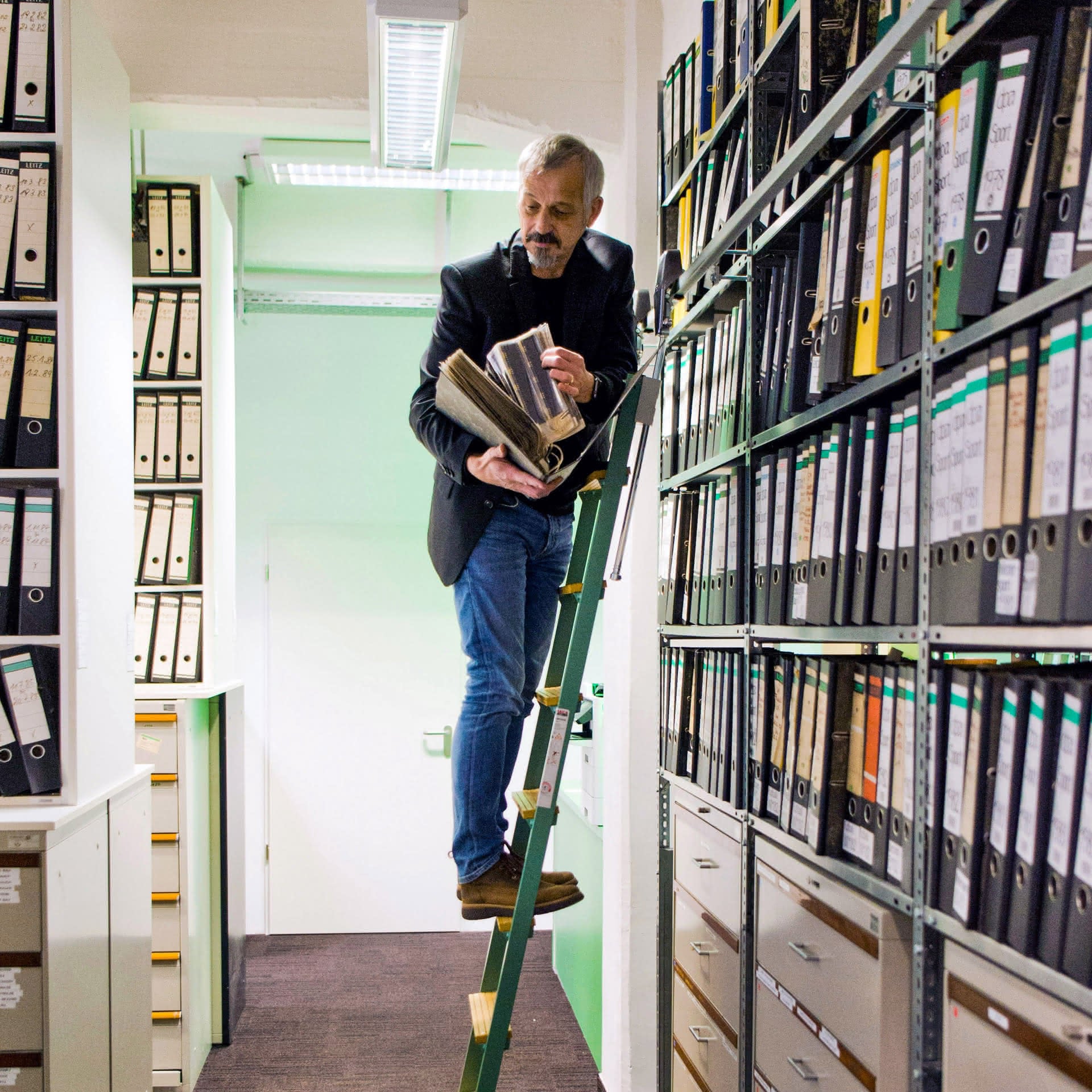 Christoph Grill, Archivexperte, sucht in hohen Regalen des dpa-Archivs nach Fotomaterial.